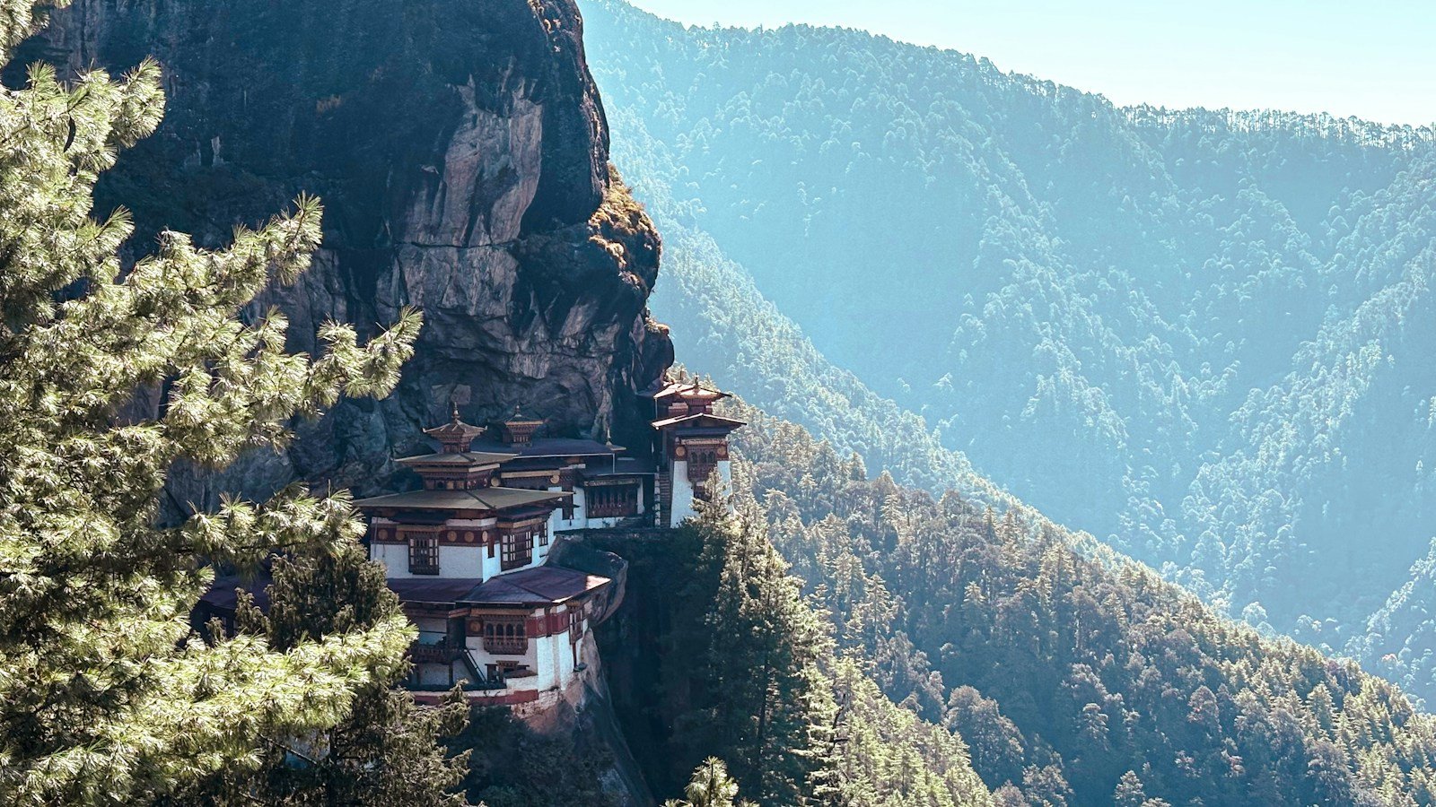 A Bhutanese monastery among forested mountains